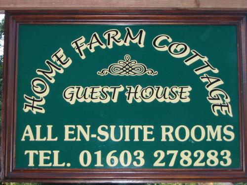 un letrero para la empresa agrícola y el hostal en Home farm cottage Guest House, en Norwich