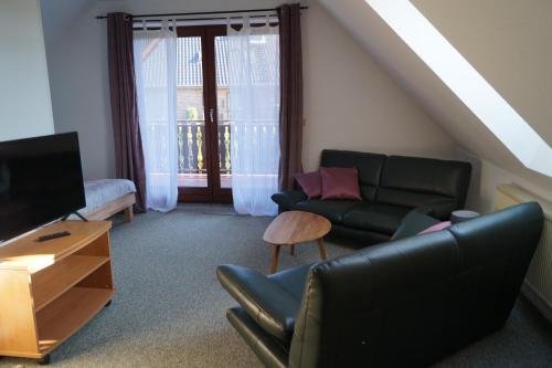 ein Wohnzimmer mit einem Sofa und einem TV in der Unterkunft Ferienzimmer Segeberg in Bad Segeberg