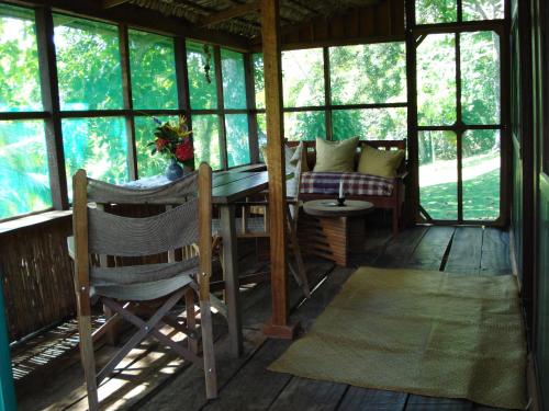 a screened in porch with a table and chairs at Hotel Veragua River House in Sierpe
