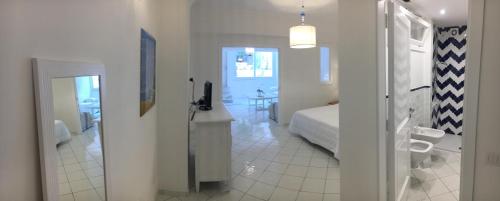 a white room with a bed and a bathroom at Marilù vacation home in Positano in Positano