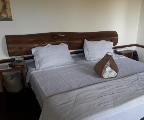a white bed with a brown bag on top of it at Chale Vista Encantada in Lavras Novas