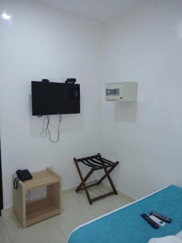 a room with a tv on a white wall at Hotel SGH Boutique Deluxe in Santa Marta
