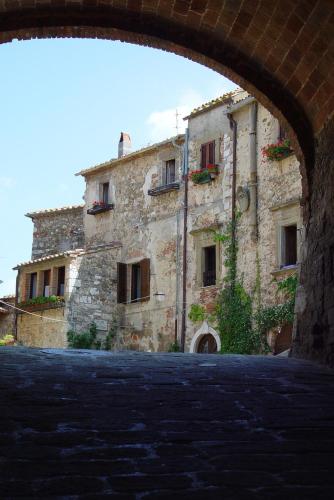a large stone building with an arch in front of it at Agriturismo Poggio alle Calle in Saturnia