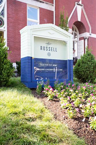 a sign in front of a building with flowers at The Russell in Nashville