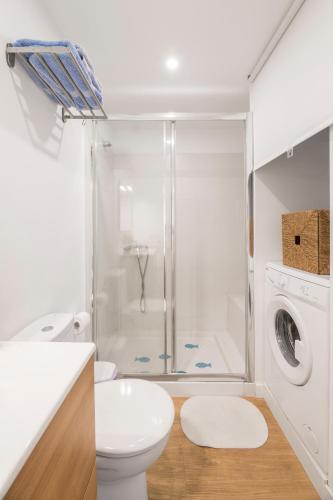a bathroom with a shower toilet and a washing machine at Flower Beach Suite 15 in Playa Honda