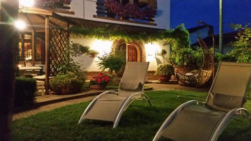 two chairs sitting in the grass in front of a house at Bed And Breakfast Olimpia in San Salvatore Monferrato