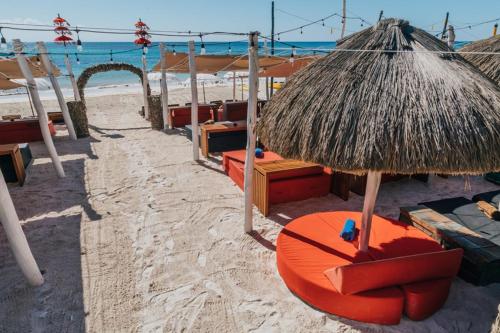 an orange chair and an umbrella on the beach at Serenity Authentic Glamping Tulum in Xpu Ha