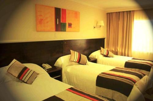 Habitación de hotel con 2 camas y teléfono en Hotel Aire de Patagonia en Río Gallegos