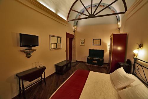 a bedroom with a bed and a flat screen tv at Residenze Gregoriane - Residenza d'Epoca in Tivoli