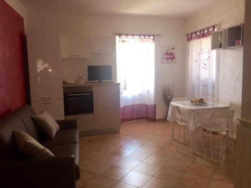 ein Wohnzimmer mit einem Sofa und einem Tisch sowie eine Küche in der Unterkunft A due passi in Pietrapertosa
