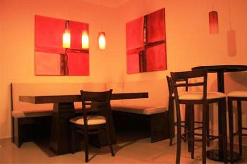 um quarto com uma mesa e cadeiras e pinturas vermelhas em Hotel Aire de Patagonia em Río Gallegos
