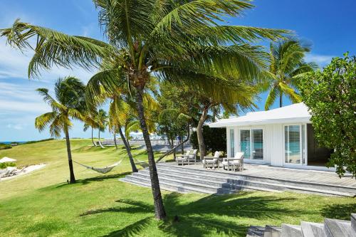 a villa with a hammock and palm trees at The Cove Eleuthera in Gregory Town