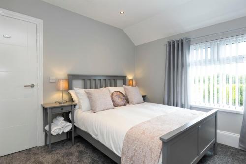 a bedroom with a large bed and a window at Chestnut House, Sleeps 11, Beautiful, spacious & comfortable in Belfast
