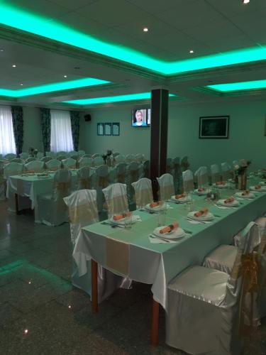 um salão de banquetes com mesas brancas e cadeiras brancas em Business Club Selenča em Bač