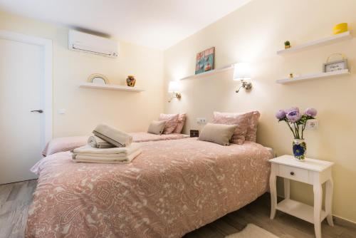 sypialnia z łóżkiem z wazonem kwiatów w obiekcie Malaga Centre Apartment with Parking w Maladze