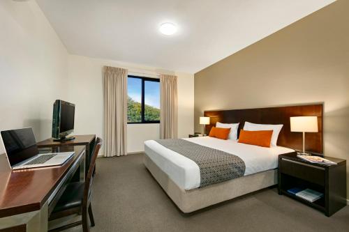 a hotel room with a bed and a desk at Quest Moorabbin in Moorabbin