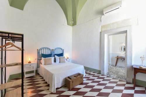 a bedroom with a bed and a checkered floor at Dimora Duchessina Suites de Charme in Minervino di Lecce