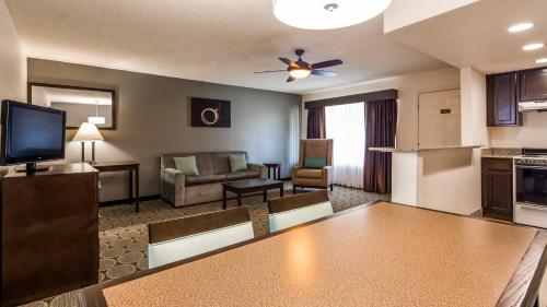 a living room with a couch a table and a kitchen at Best Western Pahrump Oasis in Pahrump