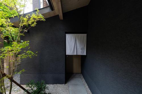 a black wall with a window with a white curtain on it at Gunjo no Tsuki in Kanazawa