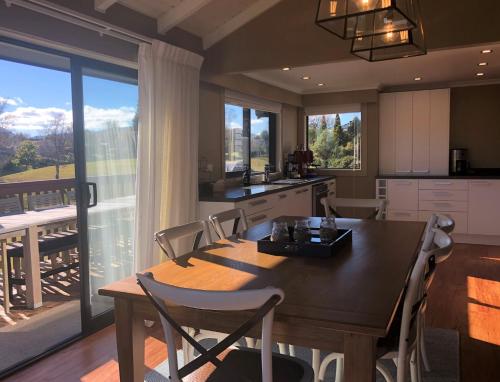 kuchnia ze stołem i krzesłami oraz duże okno w obiekcie Kinloch Lakeview Lodge - Taupo w mieście Kinloch