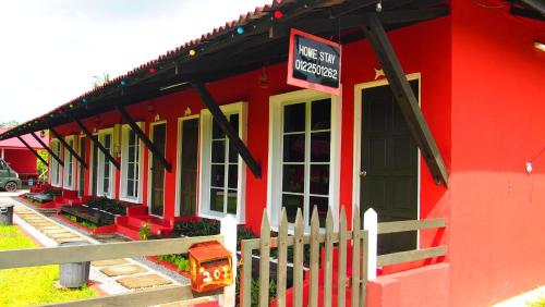 a red building with a sign that reads the next inspector at The SeaShell Chalet Melaka Kuala Sg Baru in Kampung Kuala Linggi