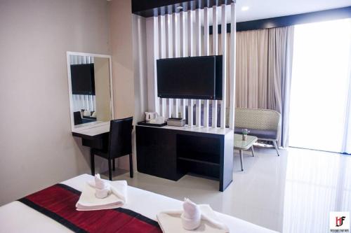a hotel room with a desk and a television at The Harbour Front Hotel in Suratthani