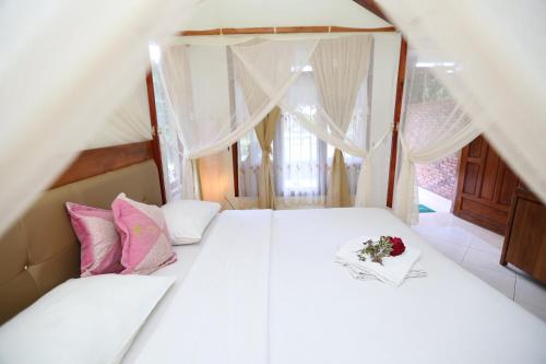 a bedroom with two beds and a bouquet of flowers at Toba Village Inn in Tuk Tuk