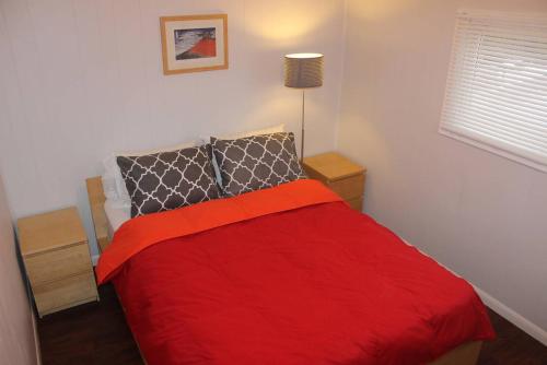 a bedroom with a red bed with two night stands at Maison Doucet in Niagara Falls