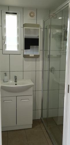 a bathroom with a sink and a glass shower at Alexandra Headland in Alexandra Headland