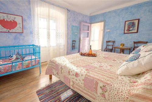 a blue bedroom with a bed and a crib at House Helena in Valtura