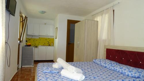 een slaapkamer met een bed met handdoeken erop bij Seaside Cabin Ksamil in Ksamil