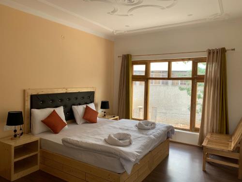 Un dormitorio con una cama grande con dos sombreros. en Gyaslang Guesthouse, en Leh