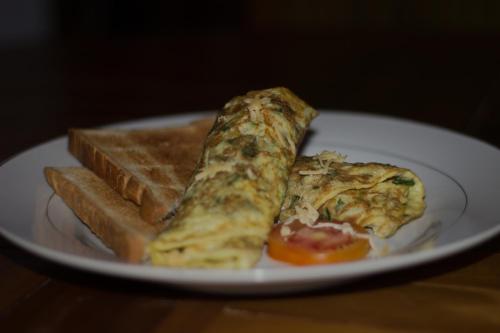 un piatto bianco con due fette di pizza e pane di My Art HOSTEL a Nusa Penida