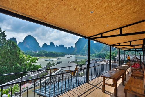 d'un balcon avec vue sur la rivière et les montagnes. dans l'établissement Yangshuo Xingping This Old Place Li-River Inn, à Yangshuo
