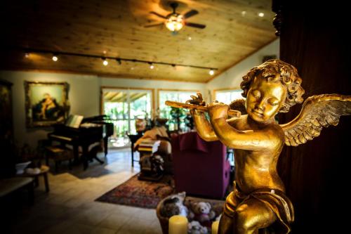 a statue of an angel holding a pipe in a living room at Shambhala Bed and Breakfast in Buckhorn