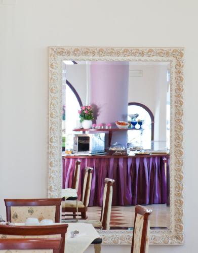 a mirror in a kitchen with a table and chairs at Hotel Vittorio in Desenzano del Garda