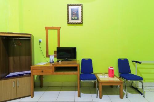 a room with a desk and two blue chairs at Pondok Green Adhyaksa Syariah in Makassar
