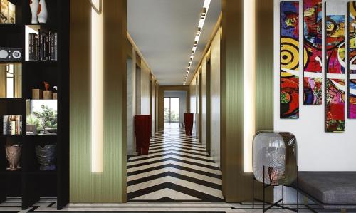 a hallway with yellow walls and striped flooring at Swiss-Belboutique Bneid Al Gar Kuwait in Kuwait