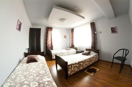 a hotel room with two beds and a chair at Zajazd Wrocławski in Kąty Wrocławskie