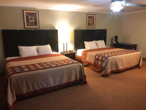 a hotel room with two beds in a room at Global Inn in Coos Bay