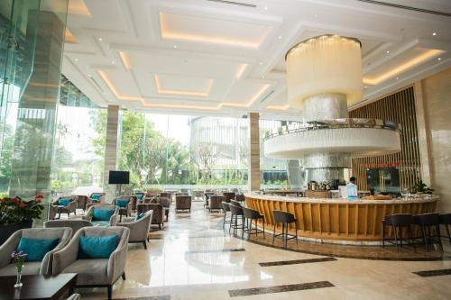 a lobby of a hotel with a bar and chairs at The Mira Central Park Hotel in Bien Hoa