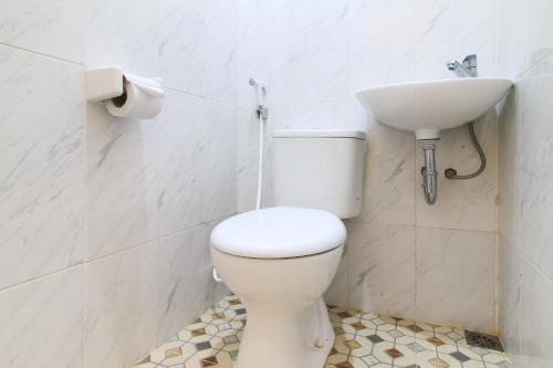 a bathroom with a white toilet and a sink at RedDoorz at Hotel Putra Perdana Klaten in Klaten