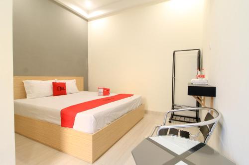 a bedroom with a bed and a chair in it at RedDoorz at Hotel Putra Perdana Klaten in Klaten