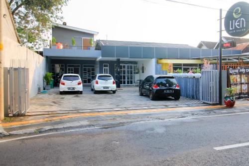 three cars parked in a parking lot in front of a building at RedDoorz at Hotel Putra Perdana Klaten in Klaten