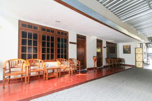 a dining room with wooden chairs and a table at RedDoorz at Hotel Putra Perdana Klaten in Klaten