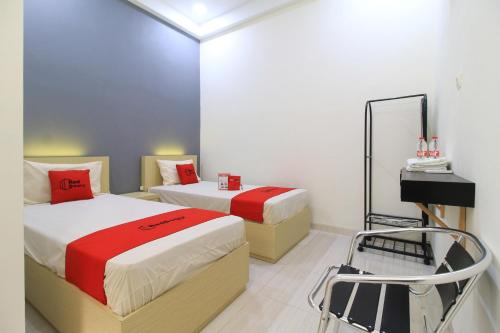 a hotel room with two beds and a mirror at RedDoorz at Hotel Putra Perdana Klaten in Klaten