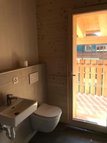 łazienka z toaletą, umywalką i oknem w obiekcie Chalet Vicky et Nino w mieście Les Diablerets
