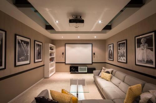 a living room with a couch and a screen at Papillon, a Relax it's Done luxury holiday home in Queenstown