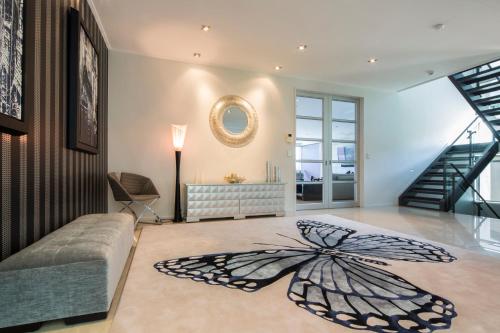 a living room with a large butterfly rug on the floor at Papillon, a Relax it's Done luxury holiday home in Queenstown