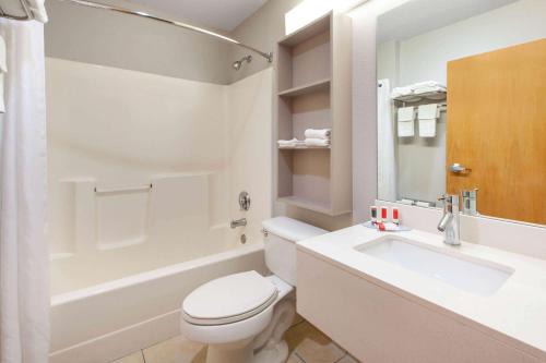 La salle de bains blanche est pourvue de toilettes et d'un lavabo. dans l'établissement Microtel Inn & Suites by Wyndham Pittsburgh Airport, à Robinson Township